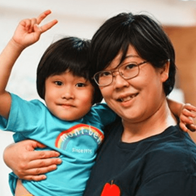 女性が子供を抱き上げる画像